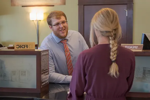 A woman speaks to a bank clerk